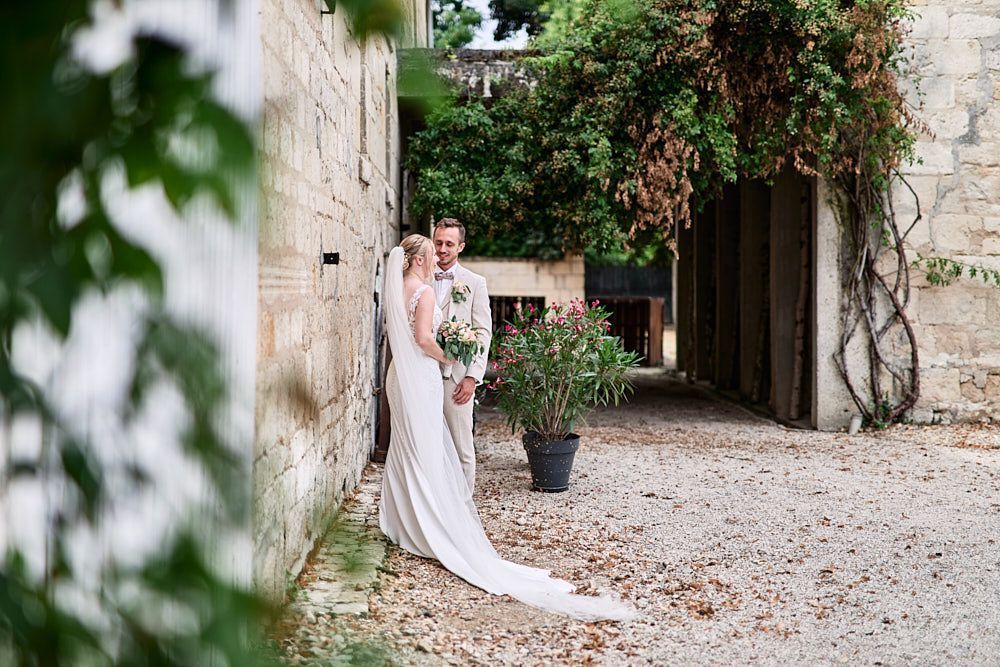 Harmonie et Anthony posent dans la cour en pierre du domaine