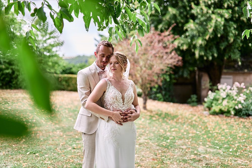 Harmonie et Anthony enlacés sous les arbres du Domaine des Pommerieux