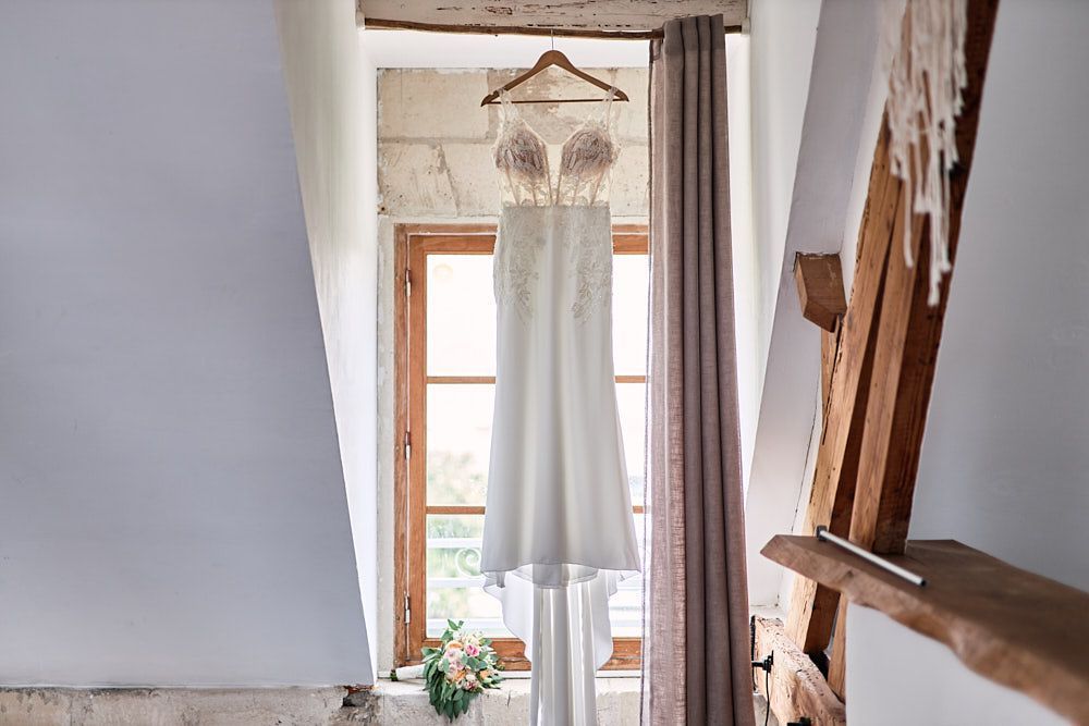 Robe de mariée et bouquet d’Harmonie dans la chambre du Domaine des Pommerieux