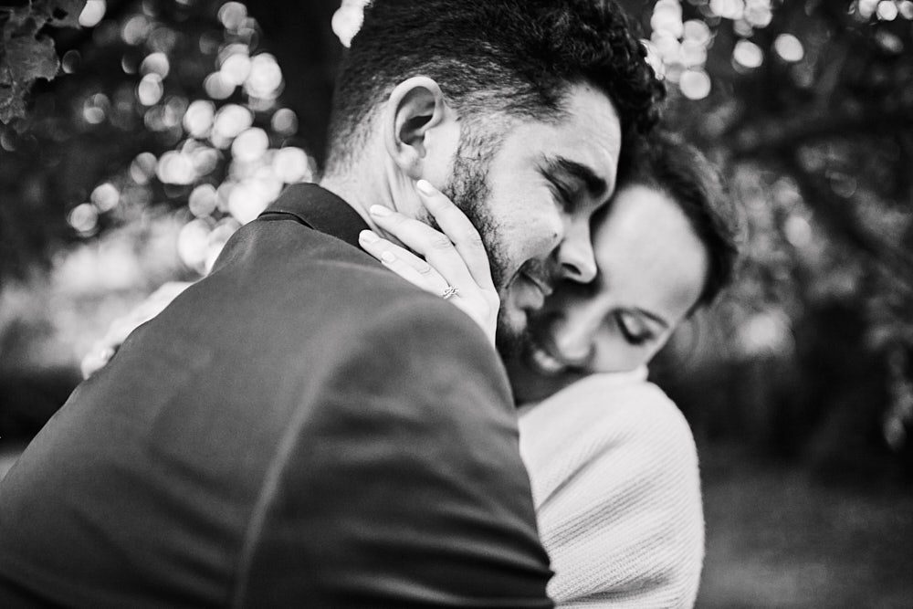 Julie et Guilhem enlacés en noir et blanc dans le jardin