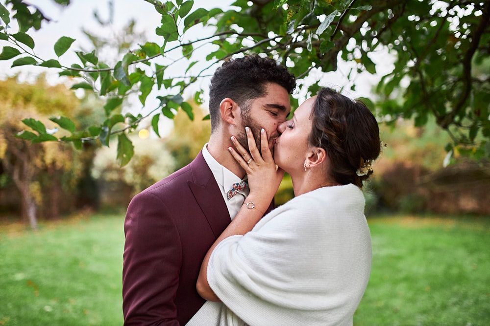Julie et Guilhem s’embrassent dans le jardin du Clos de la Robe