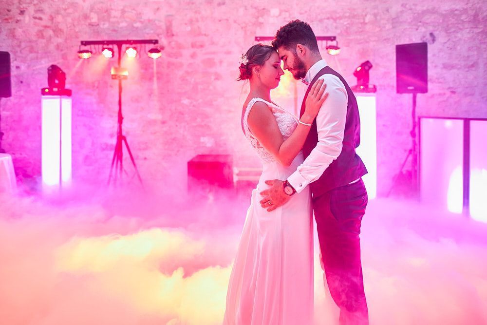 Julie et Guilhem dansent sous les lumières roses de la soirée