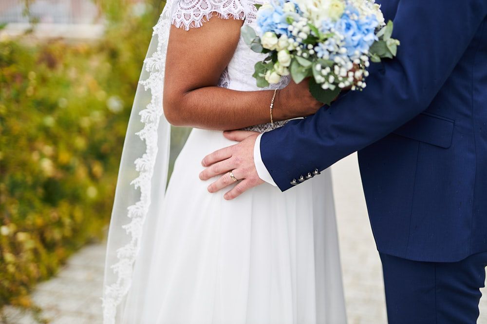 Détail de l’étreinte de Philippine et Anthony avec le bouquet de la mariée
