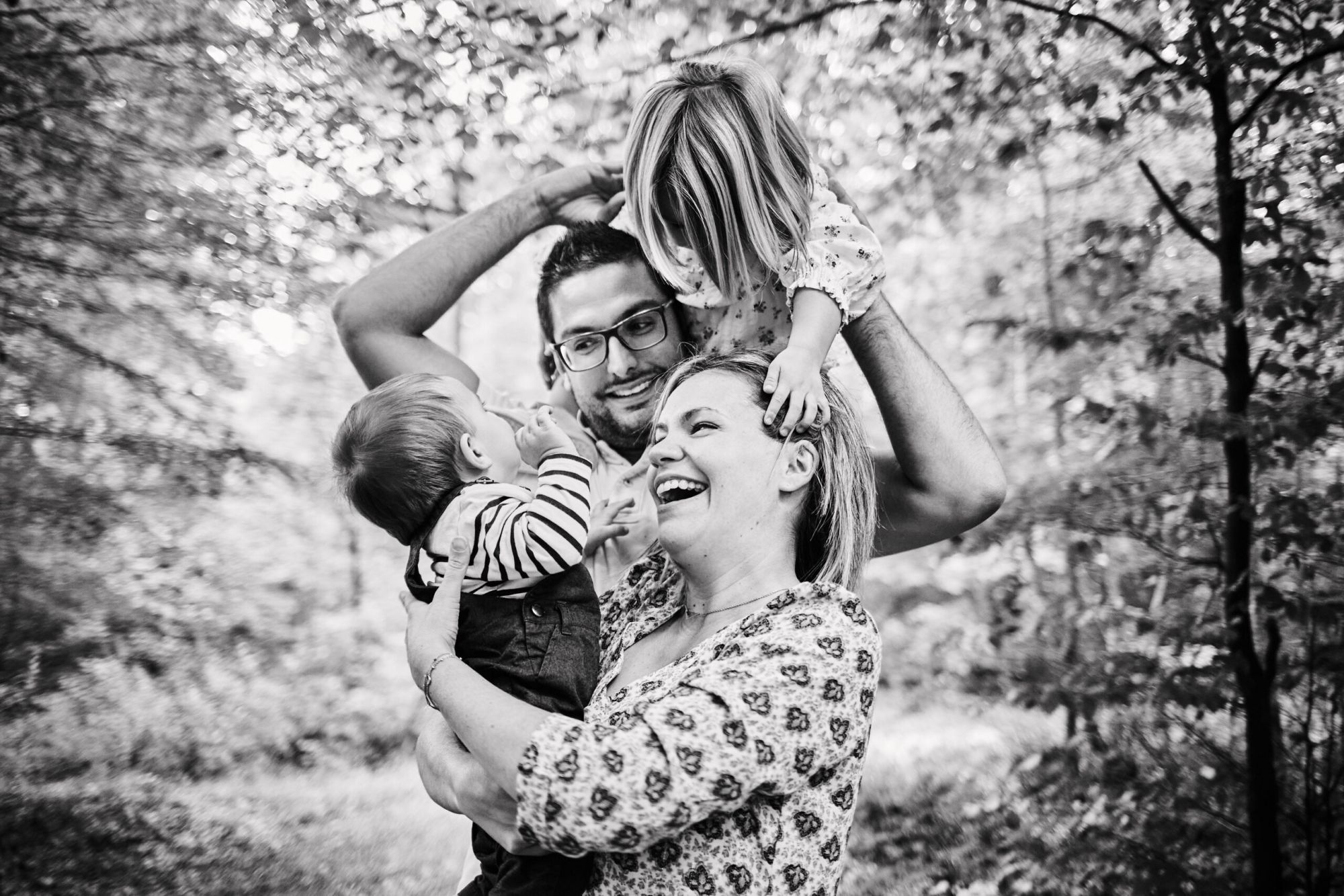 Portrait de famille en noir et blanc avec deux enfants dans un sous-bois près de Reims